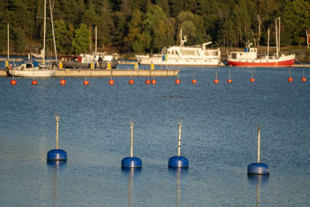 Blue mooring buoys in the yacht harbor, marina, close-up. Water surface texture. A view from the pierの写真素材