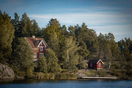 Old traditional red fisherman summer house in Sweden. scandinavian backgroundの写真素材