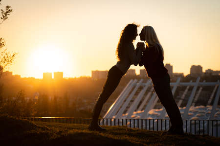 Silhouette of romantic young man and woman on sunset. Feelings, love and date conceptの写真素材