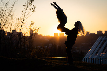 Silhouette of Happy young couple in love at sunset. Togetherness, romance conceptの写真素材