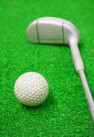 Golf ball and golf club on grass.の写真素材