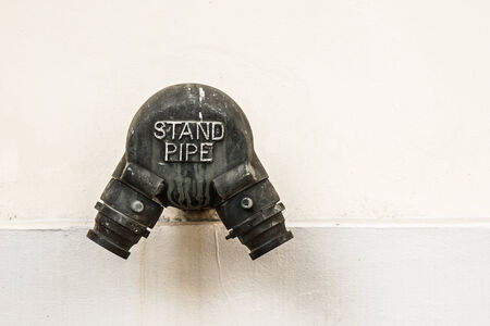 Old metal standpipe on the wall.の写真素材