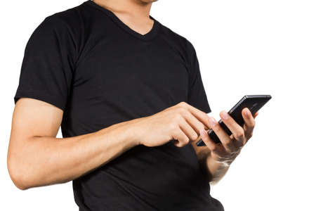 Young man body in black t-shirt with smartphone isolated on white background.の写真素材