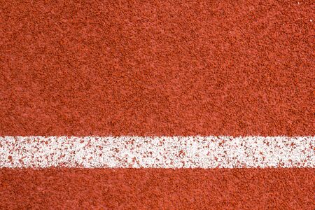Running track with white striped on redbrick color background.の写真素材
