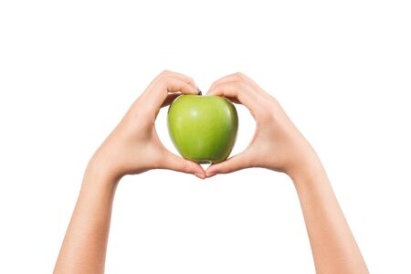 Woman hand with heart shape holding green apple isolated on white background.の写真素材