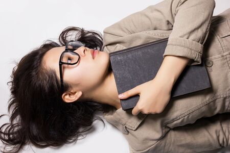 Top view of designer woman with glasses and book laying on the floor.の写真素材