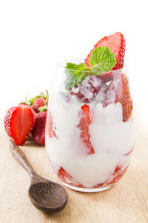Strawberry yogurt in glass with spoon on wooden board.の写真素材