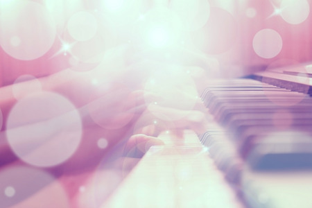 Abstract hand playing piano with bokeh and flare light, blur background.の写真素材