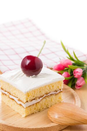 Cherry and cake with flower on wooden table.の写真素材