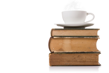 A cup of coffee on old books isolated with white background.の写真素材