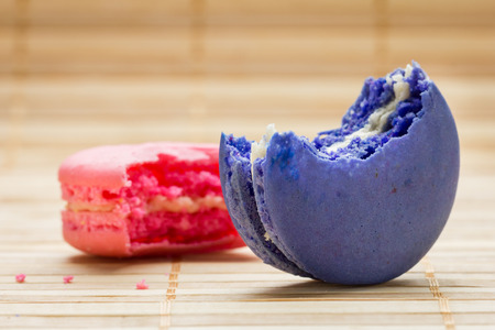 Close up colorful bite macaroons on wooden background.の写真素材