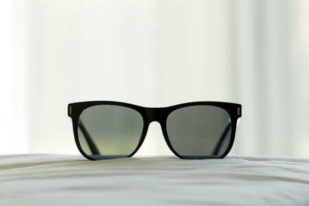 Black sun glasses in the bed room with soft focus.の写真素材