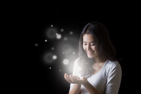 Young Asian woman opening hands with smiley face at night.