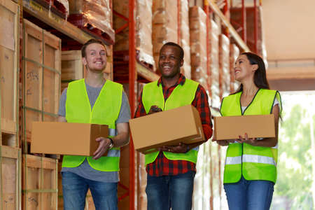 Warehouse teamwork worker holding cardboard box talking working together with happy moment,...