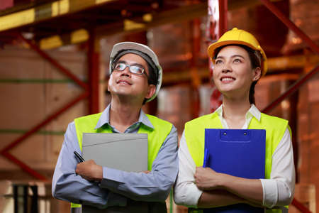looking up confident beyond business industry concept, Asian worker holding clipboard standing shin...