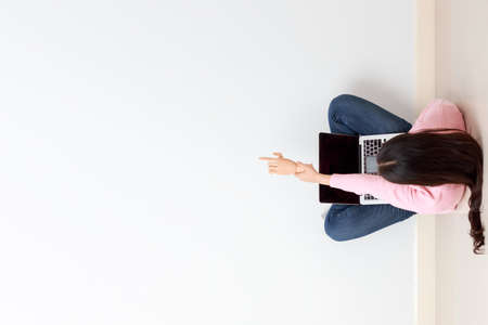 Top view of young long black hair woman as a student holding wooden hand showing pointing forward...