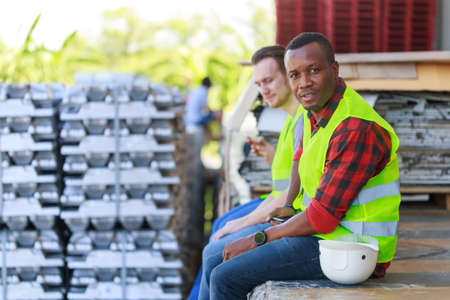 Young interracial construction industrial workers sitting relaxing during break time. Black African...