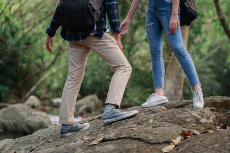 Happy couple hiking outdoors in forest. Active young Caucasian woman hiker and Asian man.の写真素材