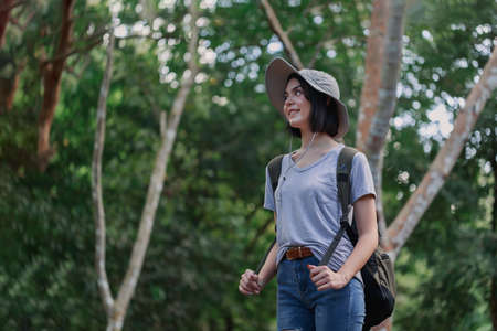 Forest hike trail hiker woman walking in autumn fall nature background in fall season. Young Caucasian woman hiking active people lifestyle wearing backpack exercising outdoors.の写真素材
