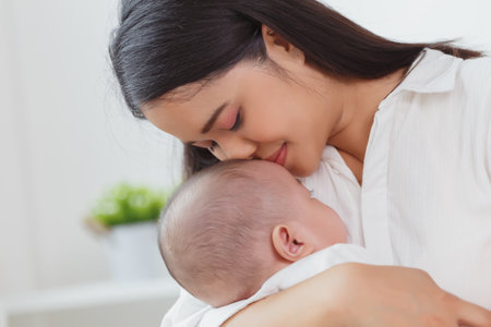 Close up portrait of young beauty Asian mother kissing her newborn baby boy while he sleep. Healthcare and medical insurance. Asia mother's day concept bannerの写真素材