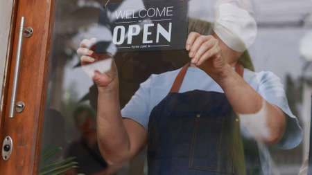 Happy Asian retire woman wearing protective face mask standing in the house as a small business...