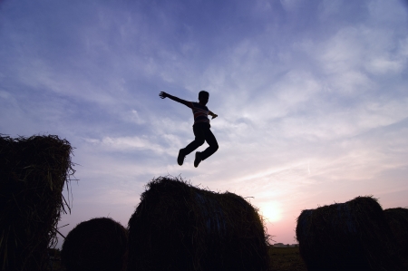silhouette of man jumping in sunset の写真素材