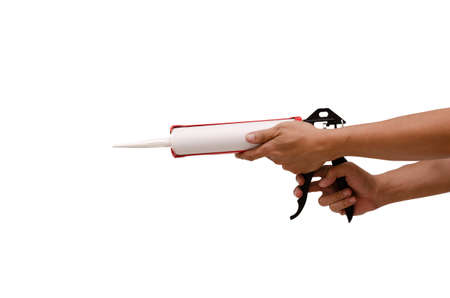 Men's hand holding Caulking gun and white silicone sealantの写真素材