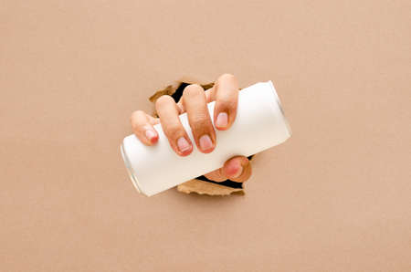 The hand hold a can through the broken wall