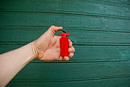 Hand with toy red fire extinguisherの写真素材