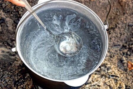 Cauldron with water and scoopの写真素材