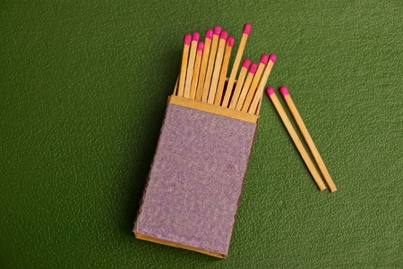 Box of matches with matches on a green backgroundの写真素材