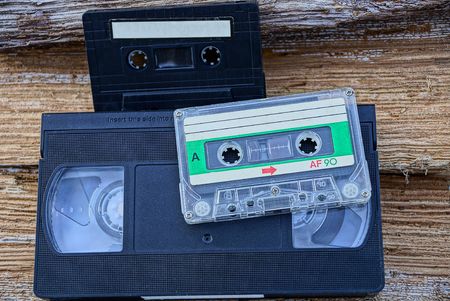Two audio cassettes and a video cassette on woodの写真素材