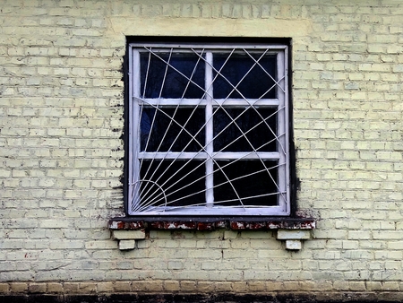 Old window with grille on the brick wallの写真素材
