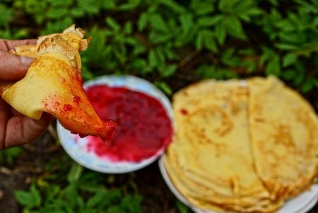 Pancakes on a plate and raspberry jam in a saucerの写真素材