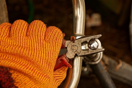 Pliers in the hand, unscrewing the iron screwの写真素材