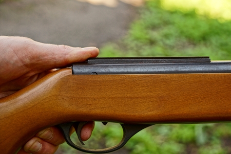 Part of the gun in hand and finger on the trigger