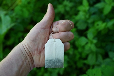 Hand in a gesture of approval with a paper tea bagの写真素材