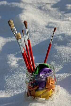 A set of brushes in a glass jar with balls on a nudeの写真素材
