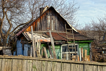 Old wooden house in the courtyard behind the fenceの写真素材