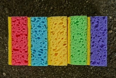 A set of colored foam sponges lying on the asphalt