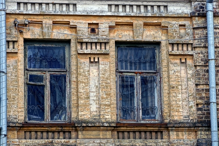 Two old windows on the brick wall of the buildingの写真素材