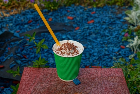 Green paper cup with coffee on the natureの写真素材