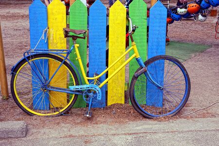 Colorful old bicycle near a wooden fenceの写真素材