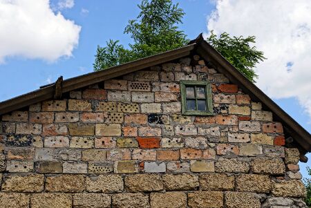The facade of the old brick building with a small windowの写真素材