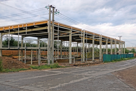 Unfinished frame of an industrial warehouse near the road