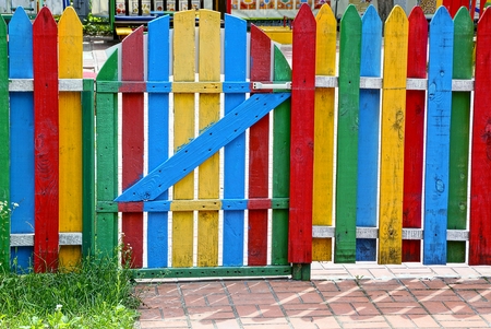 Colored wooden fence with a closed gateの写真素材