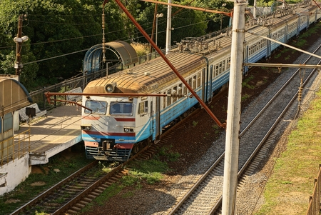 Train with passengers cars at an empty platform on the railway