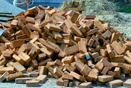 A bunch of brown bricks lie on the street on the construction siteの写真素材