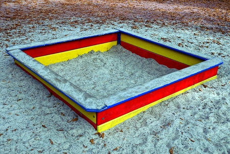 A colored wooden sandbox with gray sand on the playgroundの写真素材