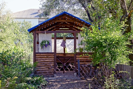 Brown wooden outdoor gazebo in the green gardenの写真素材